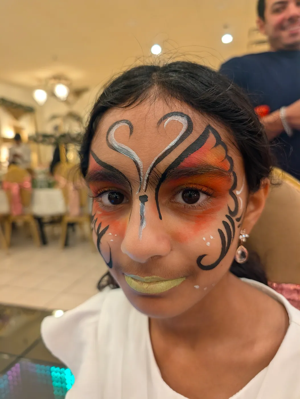 A child wearing a butterfly face-painting design